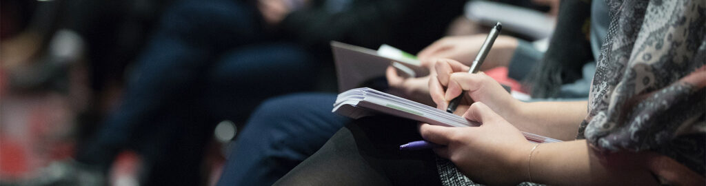 audience member writing notes in Bible